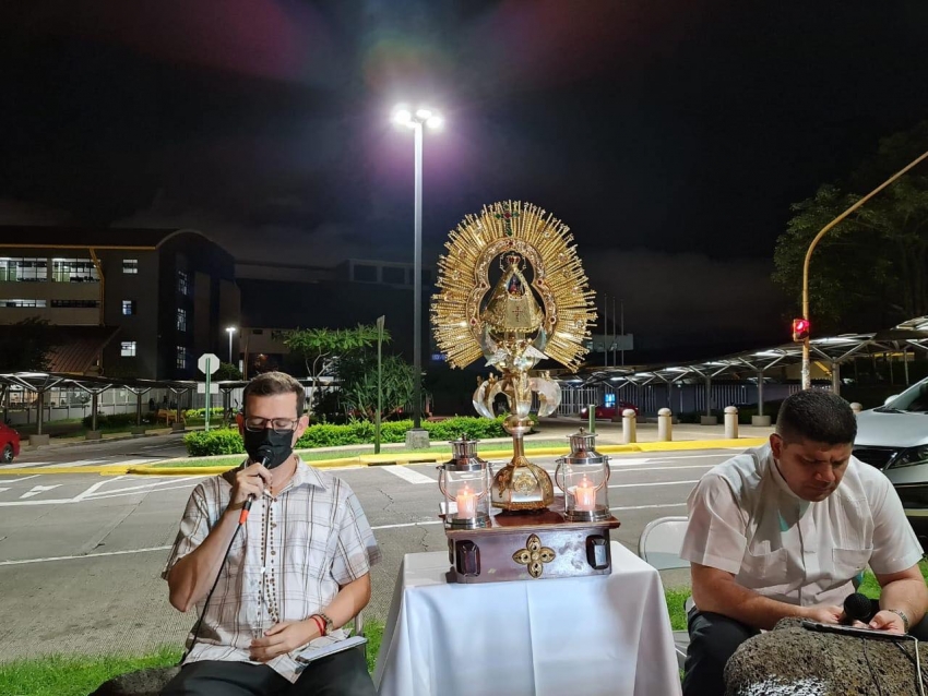 Sacerdote y colaboradores rezan frente al Hospital San Vicente de Paúl